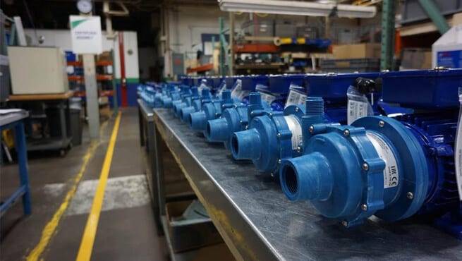 Multiple blue Finish Thompson Inc. (FTI) centrifugal pumps aligned on a factory assembly bench. Precision-engineered for industrial fluid transfer, chemical processing, and wastewater treatment systems.