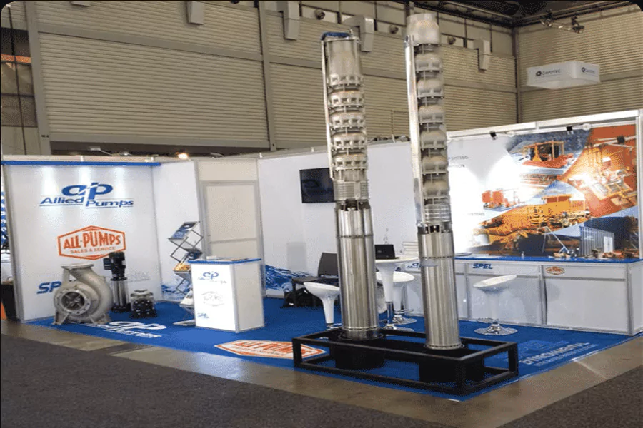 Allied Pumps and All-Pumps exhibition booth at AIMEX, showcasing large industrial pumps and promotional materials.