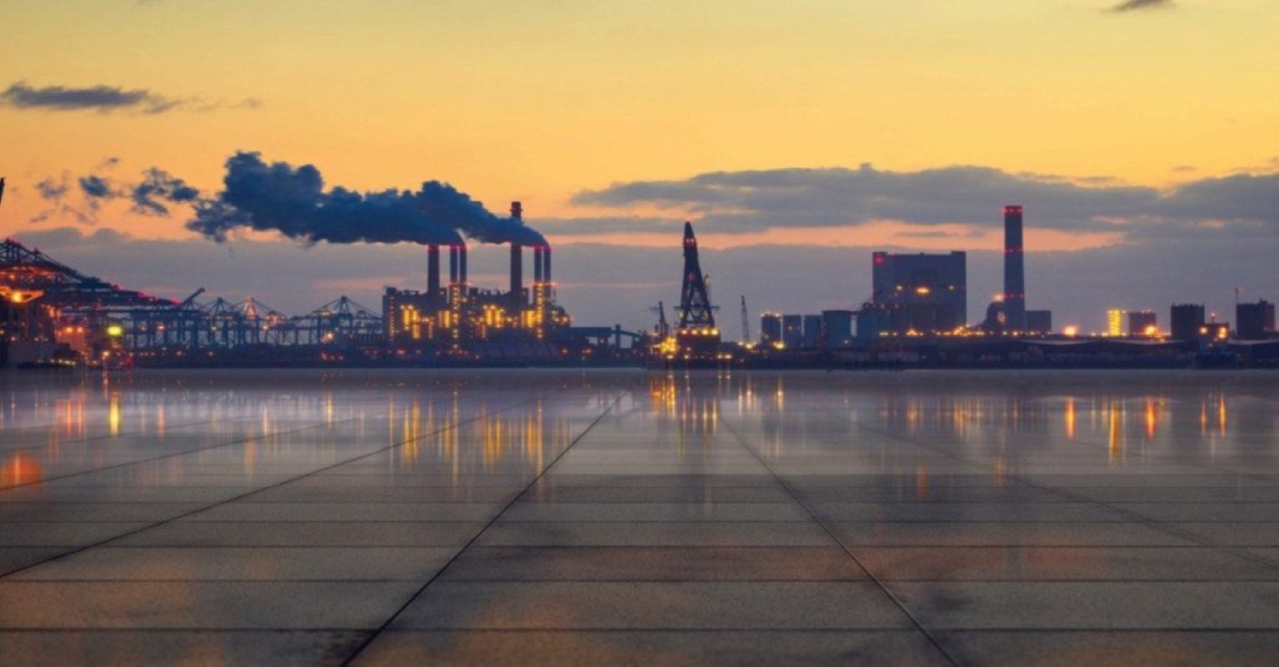 Industrial oil refinery or chemical processing plant skyline at sunset, representing the heavy-duty fluid transfer applications of Tuthill process pumps in manufacturing