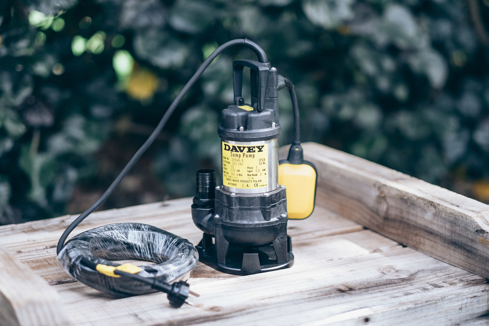 Davey submersible sump pump with yellow and black housing placed on a wooden platform. Designed for efficient groundwater removal, basement drainage, and stormwater management in domestic and light industrial applications.