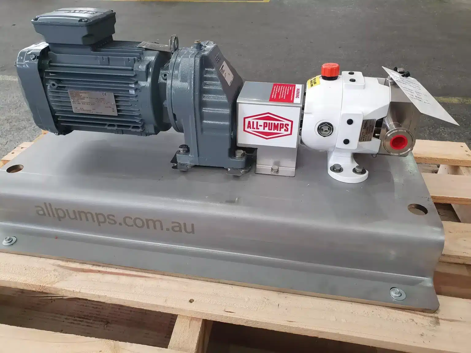 White and grey sanitary progressive cavity pump from ALL-PUMPS with an electric motor, mounted on a stainless steel skid, ideal for hygienic food-grade fluid transfer in facilities like Arnotts