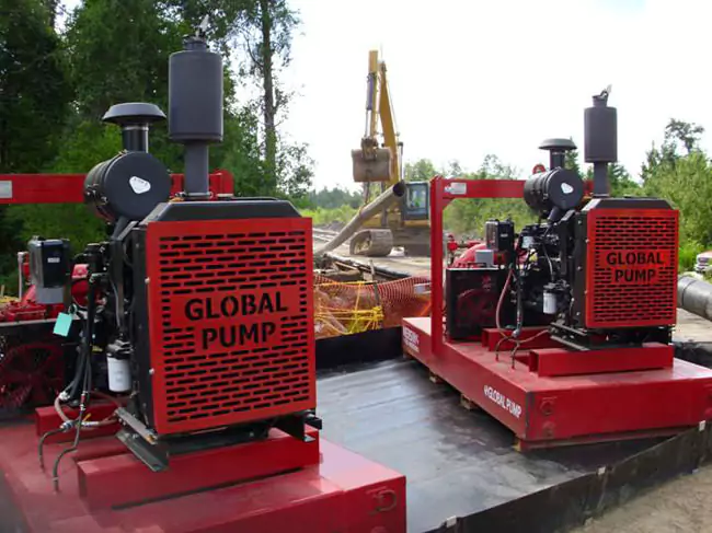 Two Global Pump GSC Wellpoint centrifugal pumps operating side by side at a pipeline installation site. The red units handle dewatering and trench drainage to support underground construction.