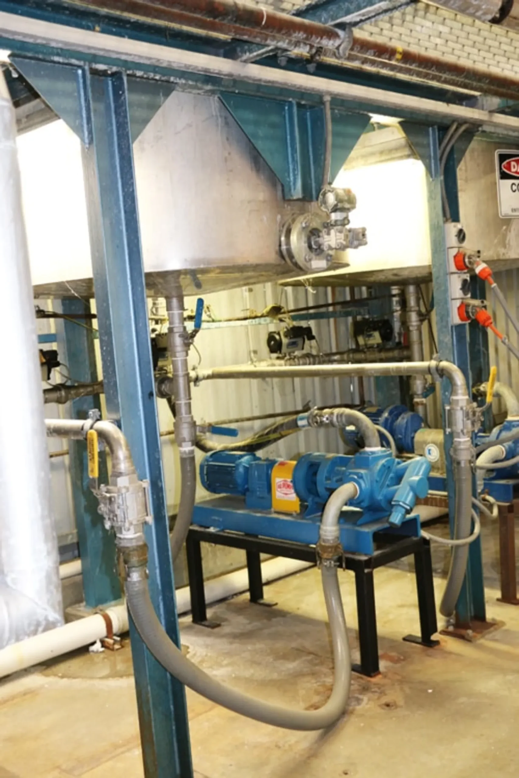 Tuthill Industrial Gear Pumps located in a room surrounded by pipes and other industrial machinery
