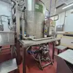 A large stainless steel tank containing a Graco Sanitary Flap Valve Diaphragm Pump, showcasing industrial equipment