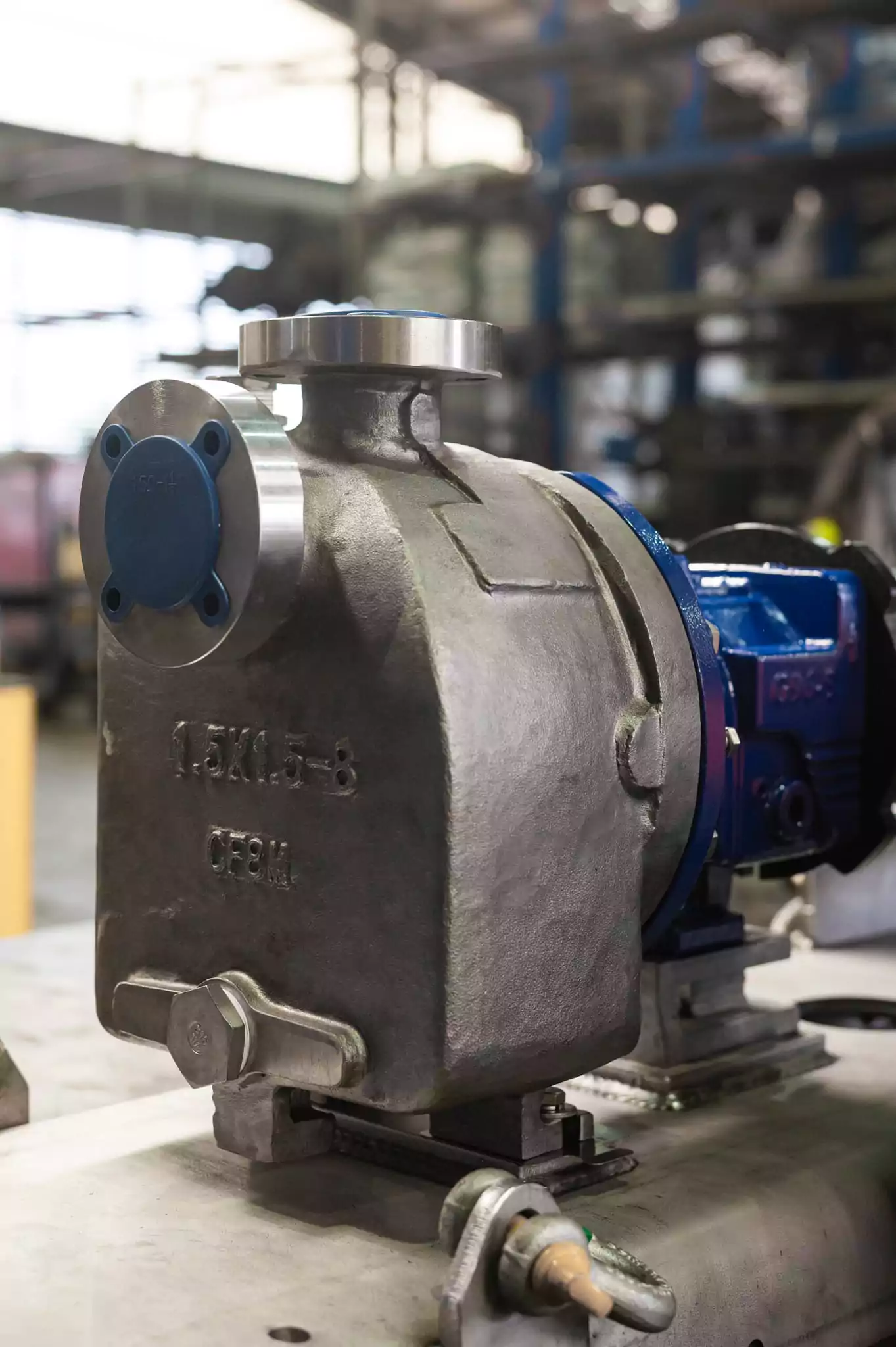 Close-up view of a Nexus industrial pump designed for commercial and municipal applications, showing the stainless steel casing and blue motor assembly inside a workshop.
