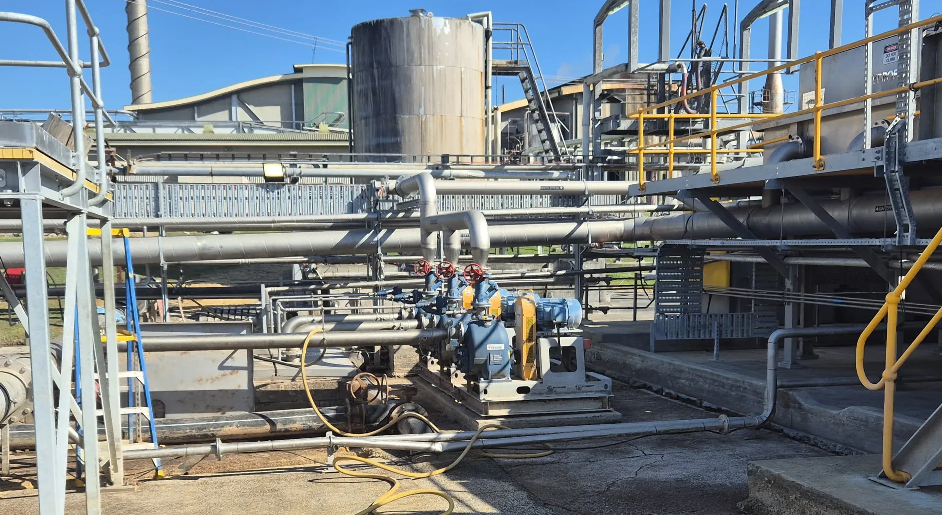 Blue WSP self-priming centrifugal pump with a yellow WEG electric motor on an industrial site.