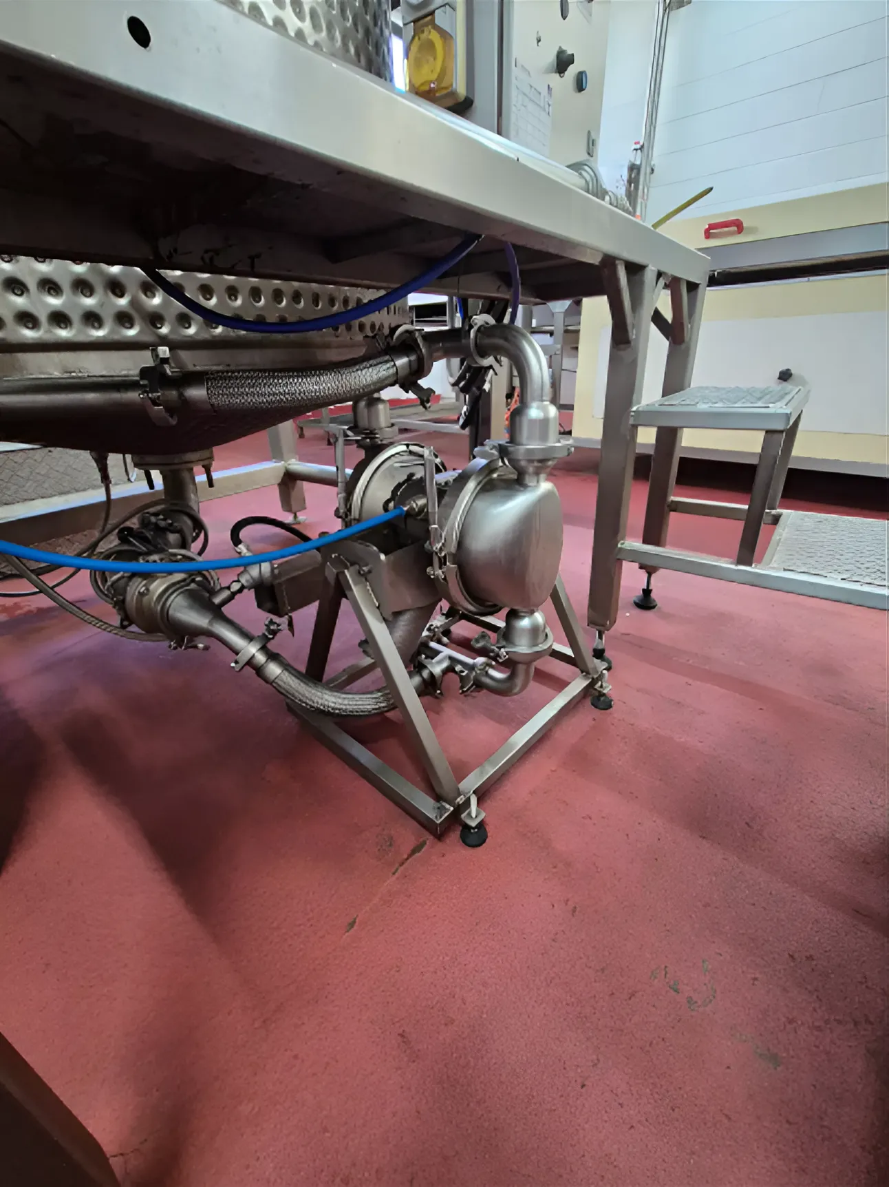 Graco SaniForce sanitary pump installed beneath a chocolate processing tank for hygienic chocolate transfer in food manufacturing.