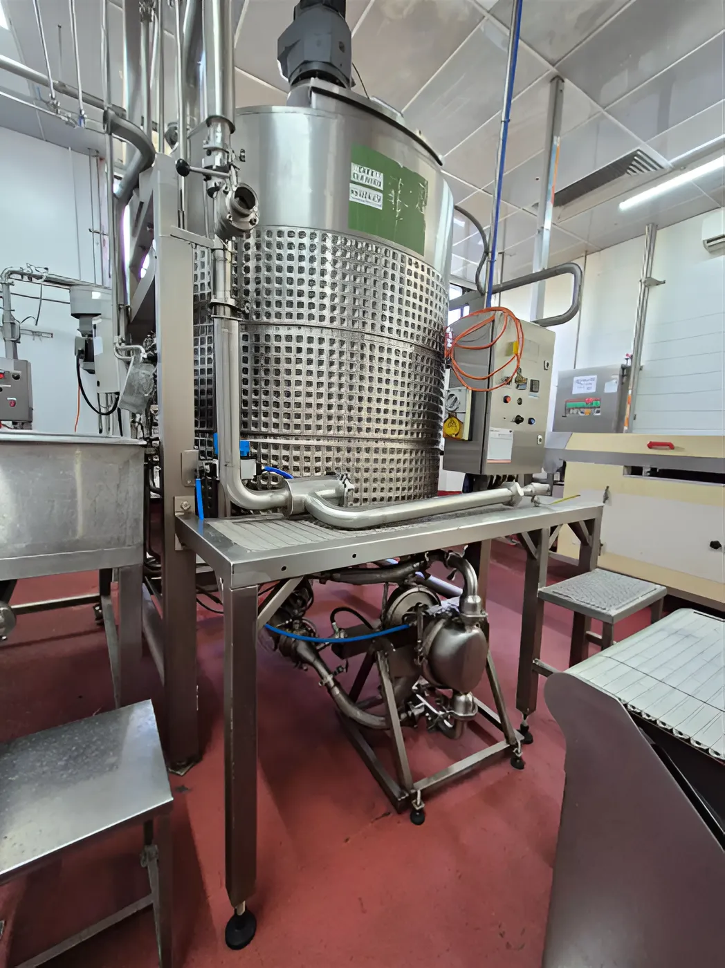 Industrial chocolate processing tank connected to a Graco SaniForce pump system for sanitary chocolate pumping and food production.