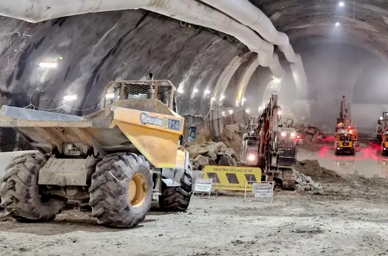 Worker and equipment inside an underground tunnel.