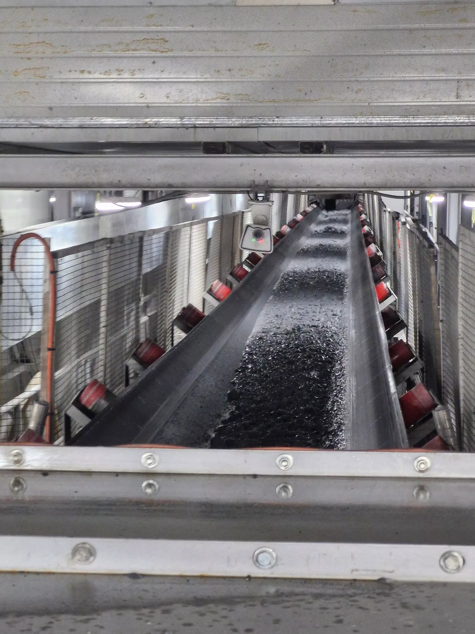 Conveyor belt transporting material inside TBM tunnelling system for powder dosing and processing.