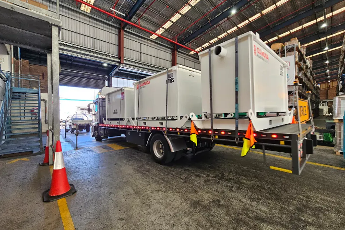 Large tanks loaded onto a truck inside a warehouse