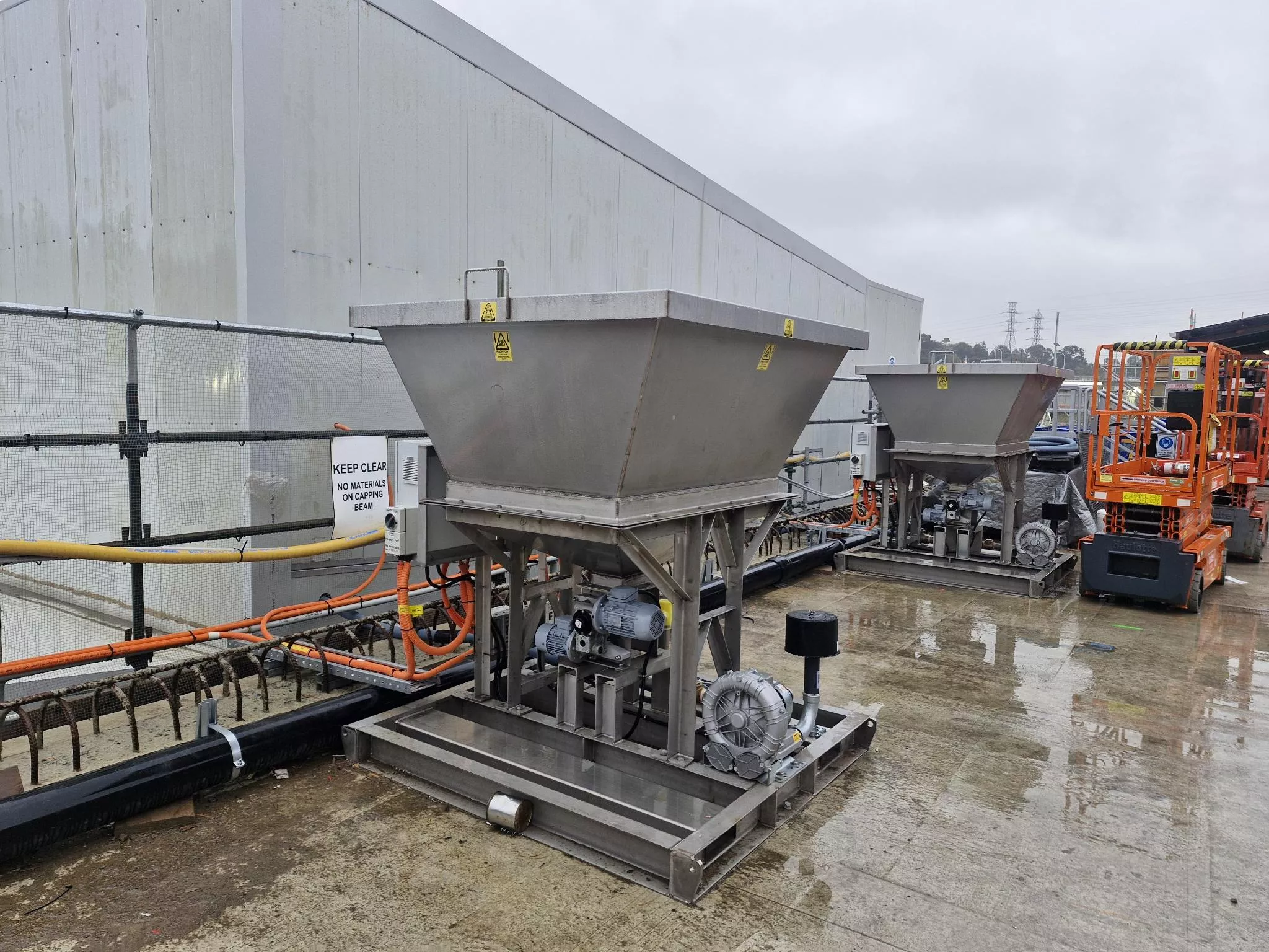 Large gray hopper unit beside an industrial building