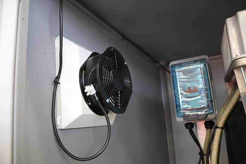 A wall-mounted fan inside a multistage pressure booster pump set.